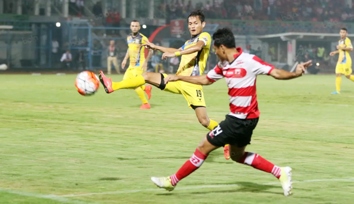 Pemain Madura United, Rendy Siregar (kanan) melepaskan umpan melewati pemain Persiba Balikpapan, Iqbal Samad pada laga Torabika SC 2016 di Stadion Gelora Bangkalan, Senin(13/6/2016).  (Bola.com/Nicklas Hanoatubun)