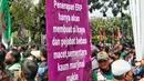 Pengemudi ojek online membentangkan spanduk tuntutan saat melakukan aksi di depan Balai Kota Jakarta, Rabu (8/2/2023). Dalam aksinya, mereka menolak penerapan jalan berbayar atau electronic road pricing (ERP) diterapkan di Jakarta. (Liputan6.com/Angga Yuniar)