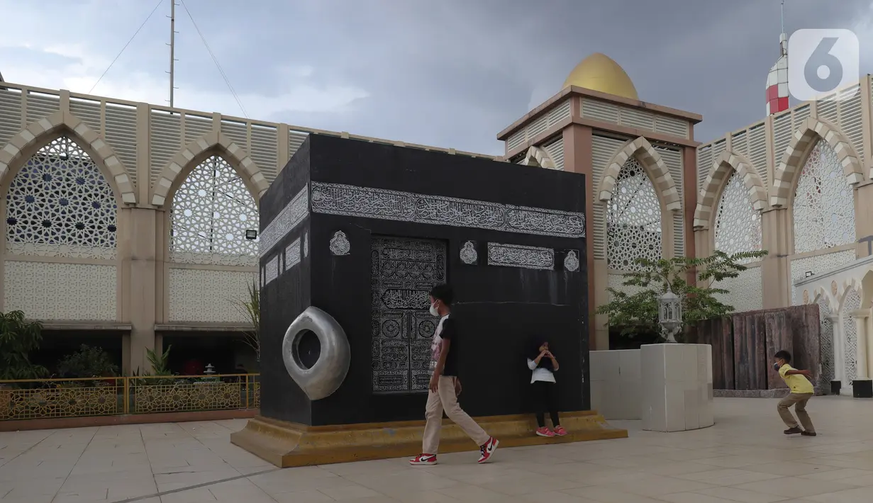 Pengunjung melintas di miniatur Kakbah di Masjid Nurul Iman, Blok M Square, Jakarta, Sabtu (2/4/2022). Miniatur Ka'bah itu sebagai fasilitas untuk calon jemaah dari agen perjalanan yang ingin melaksanakan latihan simulasi manasik haji dengan kapasitas 300 orang. (Liputan6.com/Herman Zakharia)