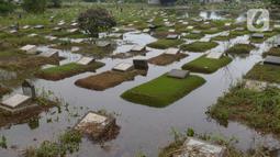 Banjir merendam sejumlah makam di Tempat Pemakaman Umum (TPU) Tanah Kusir, Jakarta, Jumat (3/1/2020). TPU Tanah Kusir terendam banjir setelah Kali Pesanggrahan meluap akibat intensitas hujan  yang tinggi pada Rabu lalu. (merdeka.com/Imam Buhori)