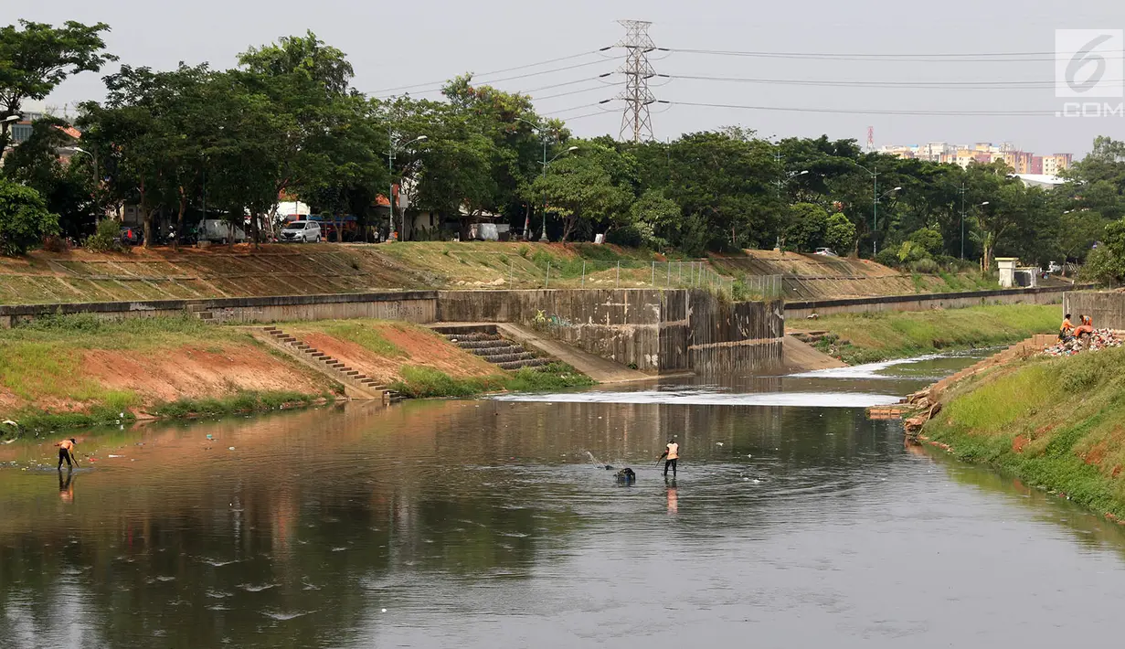 Petugas membersihkan sampah yang mengendap di Kanal Banjir Timur, Jakarta, Selasa (19/9). Selain air yang hitam, bau tak sedap juga keluar dari sungai tersebut sehingga mengganggu pernafasan warga. (Liputan6.com/Immanuel Antonius)