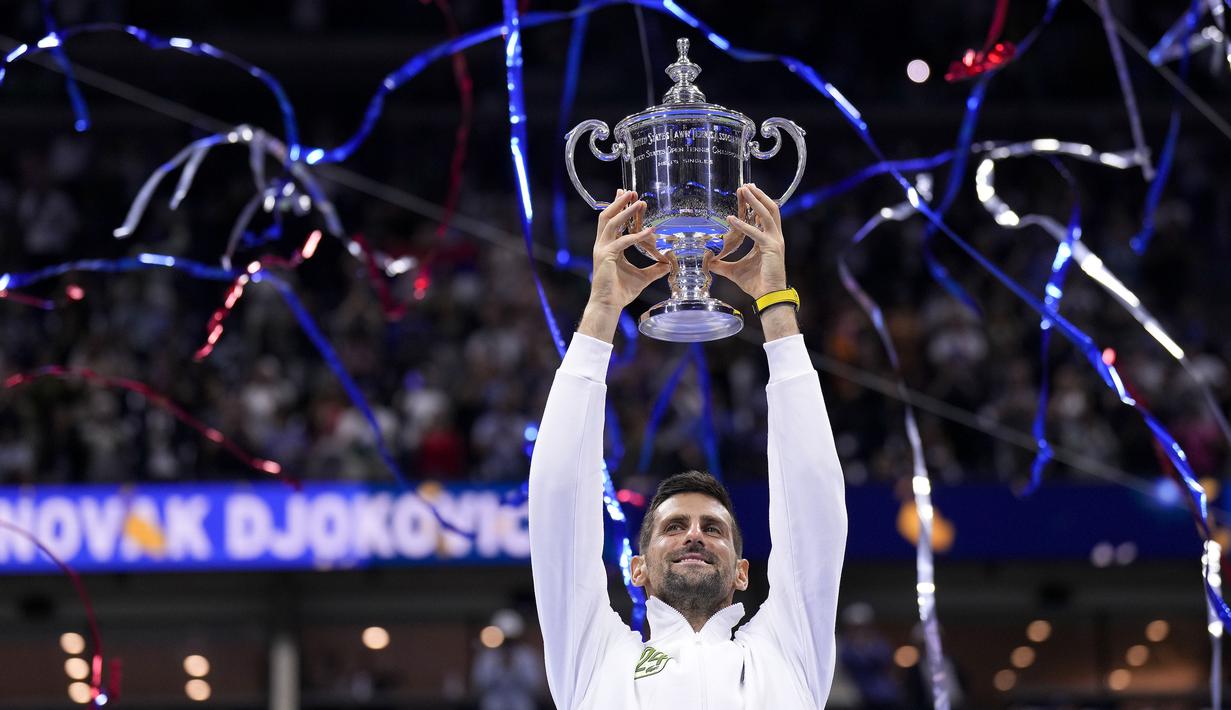 Petenis asal Serbia, Novak Djokovic, mengangkat trofi gelar juara US Open 2023 setelah mengalahkan petenis asal Rusia Daniil Medvedev dalam partai final yang berlangsung di Arthur Ashe, New York, Senin (11/9/2023) pagi WIB. Trofi ini merupakan gelar US Open keempat kalinya, dari 10 kali final yang telah dijalani oleh Djokovic. (AP Photo/Manu Fernandez)