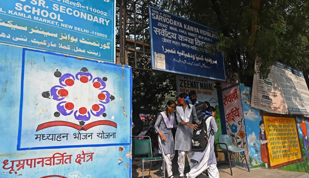 Para siswa berfoto di luar sebuah sekolah di New Delhi (15/11/2021). Sejumlah rumah sakit di Indoa juga sudah melaporkan peningkatan tajam jumlah pasien dengan keluhan kesulitan bernapas. (AFP/Money Sharma)