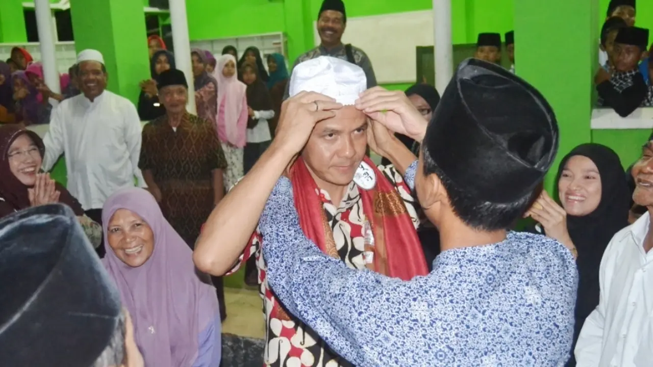 Seorang santri di Ponpes El Bayan, Majenang, Cilacap, memakaikan kopyah kepada Gubernur Jawa Tengah, Ganjar Pranowo. (Foto: Liputan6.com/Muhamad Ridlo)