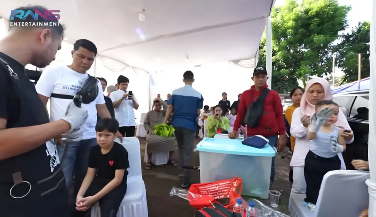 Tidak hanya melihat, Raffi juga turun langsung memotong sapi pertama. Raffi melepas baju koko dan mengenakan perlengkapan sebelum memotong sapi pertama. [Youtube/Rans Entertainment]