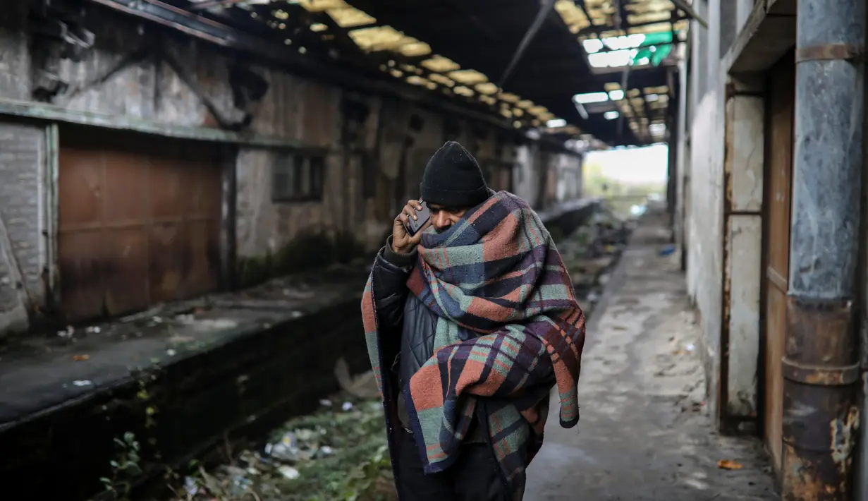 Imigran menggunakan telepon selular di sudut sebuah gudang tak terpakai yang dijadikan tempat tinggal di Belgrade, Serbia, 11 November 2016. Menurut badan pengungsi PBB, sekitar 6.400 imigran saat ini terdaftar di Serbia. (REUTERS/Marko Djurica)