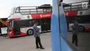 Petugas berada di dekat bus transjakarta yang akan digunakan untuk pawai kemenangan tim Persija Jakarta di kantor PT Transjakarta, Cawang, Kamis (13/12). Bus tersebut akan digunakan untuk pawai kemenangan Persija. (Liputan6.com/Immanuel Antonius)