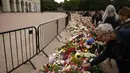 Seorang pria meletakkan setangkai mawar saat ia dan para pelayat berkumpul di sebuah tugu peringatan bunga dadakan untuk memberikan penghormatan kepada Raja Harald V dari Norwegia yang telah wafat, di alun-alun Istana Kerajaan di Oslo, Norwegia, Jumat, 28 Agustus 2026. (AFP/ Odd Andersen)
