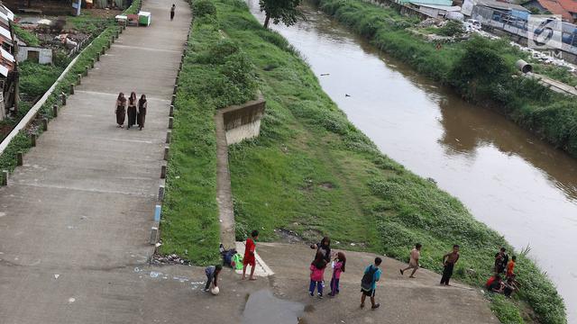 Keseruan Anak-Anak Bermain Sepak Bola di Jalur Inspeksi Ciliwung