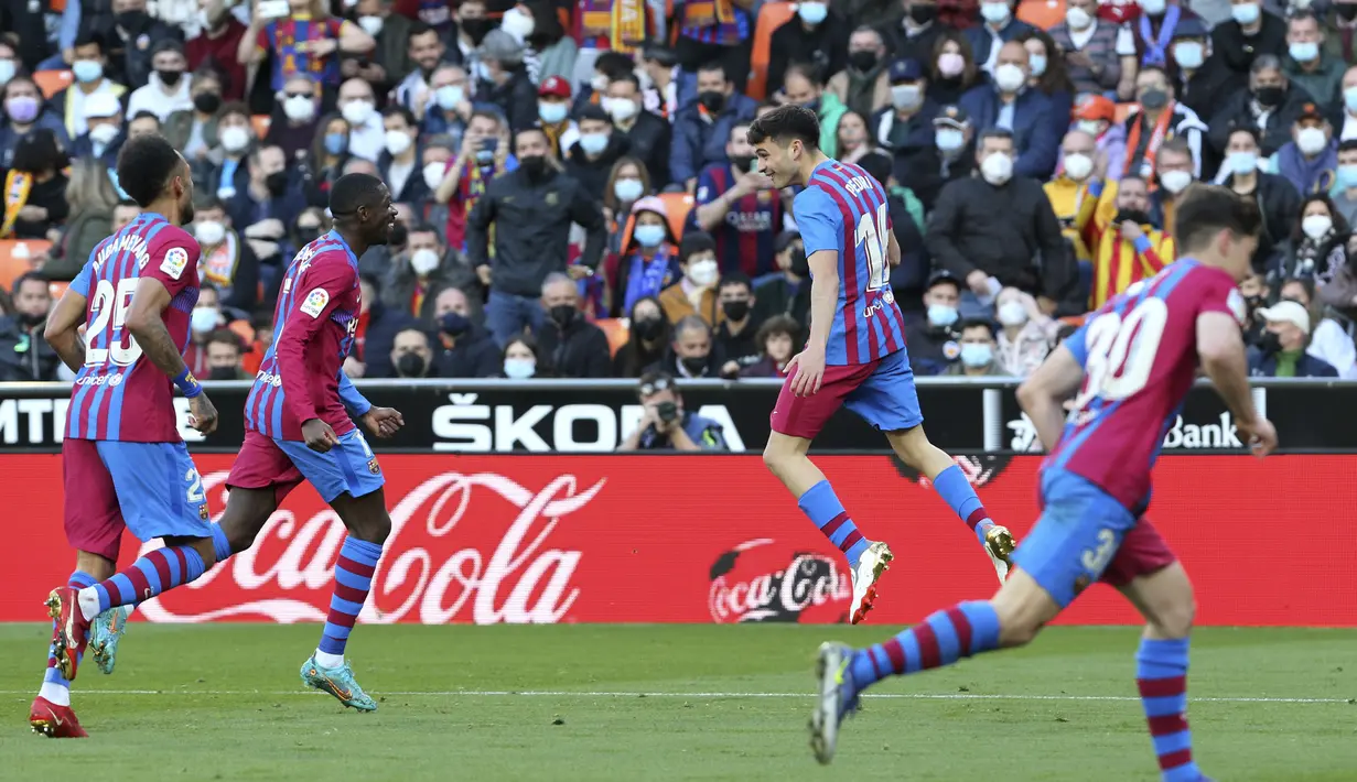 Gelandang Barcelona, Pedri (ketiga kiri) berselebrasi dengan rekan setimnya usai mencetak gol ke gawang Valencia pada pertandingan La Liga Spanyol di stadion Mestalla, Spanyol, Minggu (20/2/2022). Barcelona menang atas Valencia 4-2. (AP Photo/Alberto Saiz)
