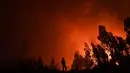 Seorang petugas pemadam kebakaran memantau kebakaran di Amendoa di Macao, Portugal tengah (21/7/2019). Lebih dari seribu petugas pemadam kebakaran berjuang untuk memadamkan kebakaran hutan tersebut. (AFP Photo/Patricia De Melo Moreira)