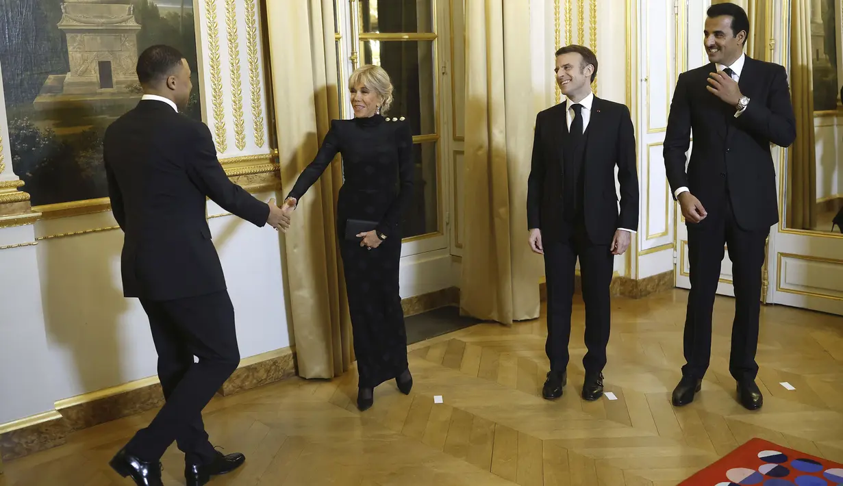 Pemain PSG, Kylian Mbappe (kiri) bersalaman dengan Ibu Negara Prancis, Brigitte Macron saat diundang menjadi salah satu tamu di Istana Elysee, Prancis, Selasa (27/2) malam waktu setempat. Mbappe diundang dalam acara makan malam oleh Presiden Prancis, Emmanuel Macron untuk menghormati kedatangan Emir Qatar, Sheikh Tamin bin Hamad Al-Thani (AP Photo/Thibault Camus)
