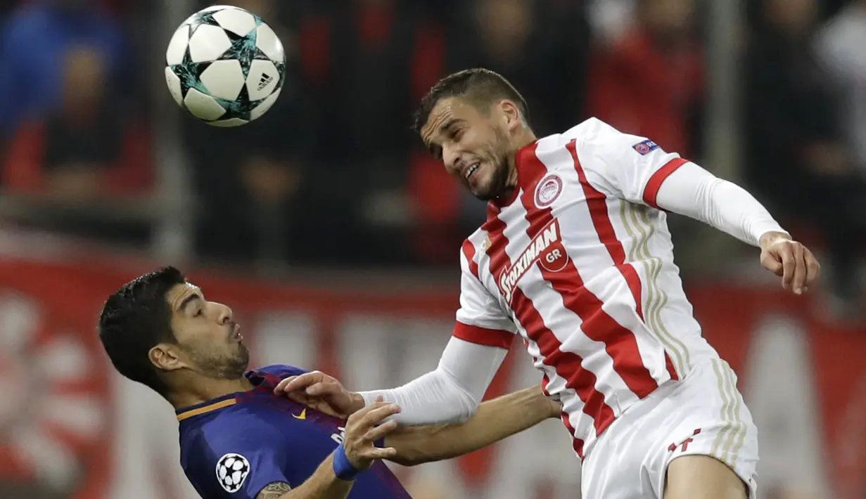 Striker Barcelona, Luis Suarez, duel udara dengan bek Olympiakos, Omar Elabdellaoui, pada laga Liga Champions di Stadion Karaiskakis, Selasa (31/10/2017). Barcelona bermain imbang 0-0 dengan Olympiakos. (AP/Thanassis Stavrakis)