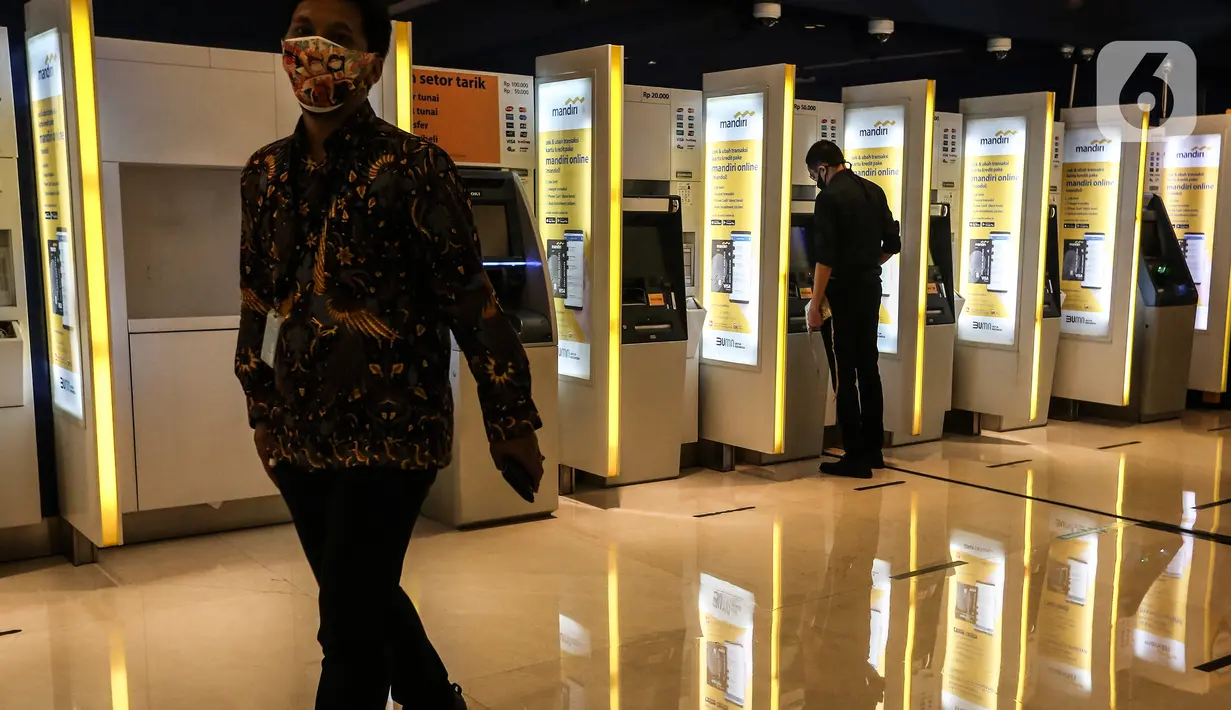Seorang pria melintas di depan anjungan tunai mandiri (ATM), Jakarta, Senin (25/1/2020). Kinerja kredit perbankan pada 2021 diperkirakan tumbuh positif sebesar 7,3 persen secara tahunan (year-on-year/yoy). (Liputan6.com/Johan Tallo)