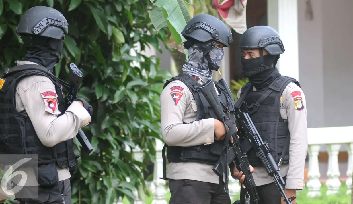 Petugas Kepolisian Brimob berjaga disekitar area rumah terduga teroris di Setu, Tangerang Selatan, Rabu (21/12). Sebelum membekuk terduga, polisi sudah memperingatkan mereka agar menyerahkan diri. (Liputan6.com/Helmi Affandi)