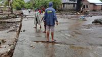 Warga memeriksa kerusakan di desa yang terkena banjir di Ile Ape, di Pulau Lembata, provinsi Nusa Tenggara Timur, Minggu (4/5/2021). Cuaca ekstrem yang mengakibatkan banjir bandang disertai hujan lebat dan angin kencang menerjang sejumlah kawasan di NTT dan NTB. (AP Photo/Ricko Wawo)