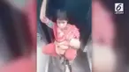Bukannya duduk di salah satu gerbong, wanita ini memutuskan duduk di besi penghubung antar kereta sambil membawa sang bayi.