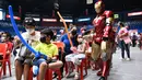 Seseorang berkostum superhero Ironman berjalan melewati anak-anak yang menunggu giliran disuntik vaksin Covid-19 Pfizer-BioNtech untuk anak-anak berusia 5-11 di sebuah gym di San Juan City, pinggiran kota Manila, Filipina pada 7 Februari 2022. (Ted ALJIBE / AFP)
