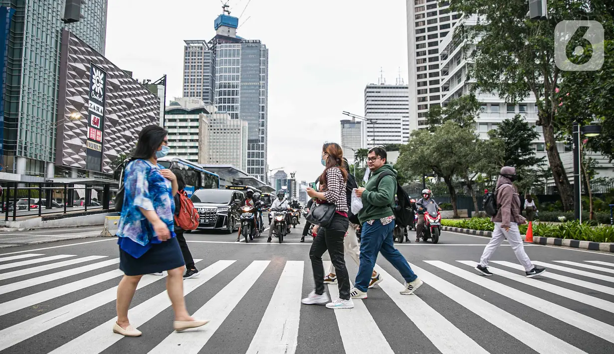 Pejalan kaki menyeberang jalan di kawasan Sudirman, Jakarta Pusat, Rabu (6/1/2021). Pemerintah memberlakukan kebijakan pembatasan sosial berskala besar (PSBB) di wilayah Jawa dan Bali mulai 11 hingga 25 Januari 2021 menyusul lonjakan kasus Covid-19 di sejumlah daerah. (Liputan6.com/Faizal Fanani)