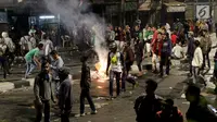 Massa berkumpul dan membakar kardus saat terjadi ricuh akibat unjuk rasa di sekitar jalan Pejompongan, Jakarta, Rabu (25/9/2019). Sebelumnya, unjuk rasa yang dilakukan pelajar STM bentrok dengan aparat kepolisian dibelakang Gedung DPR/MPR. (Liputan6.com/Helmi Fithriansyah)