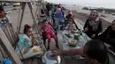 Anggota keluarga menyiapkan makanan mereka sambil menunggu berbuka puasa saat bulan suci Ramadan di pantai Kota Gaza, Palestina, Kamis (21/5/2020). Di tengah pandemi COVID-19, berbuka puasa bersama di pantai Kota Gaza tetap ramai. (AP Photo/Adel Hana)