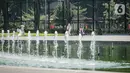 Warga menikmati air mancur di Lapangan Banteng, Jakarta, Sabtu (23/10/2021). Pembukaan 59 RTH ini menyusul penurunan status Pemberlakuan Pembatasan Kegiatan Masyarakat atau PPKM Jakarta yang kini berada di level dua. (Liputan6.com/Faizal Fanani)
