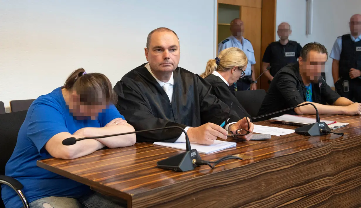 Terdakwa Berrin T (kiri) dan Christian L (kanan) menunggu sidang putusan di pengadilan distrik di Freiburg, Jerman, Selasa (7/8). Berrin dan Christian melacurkan putranya via situs paedofil antara Mei 2015 hingga Agustus 2017. (THOMAS KIENZLE/AFP)
