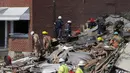 Pihak berwenang berjalan di antara tumpukan puing dari ledakan di Baltimore, Maryland, Amerika Serikat, Senin (10/8/2020). Sejumlah petugas terus melakukan pencarian orang-orang yang mungkin terjebak dalam puing-puing. (AP Photo/Julio Cortez)