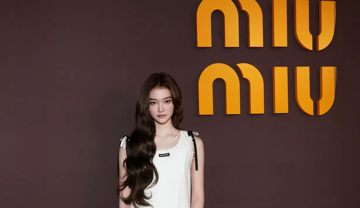 Ella Gross dari MEOVV tampil dengan pendekatan minimal yang youthful. Ia mengenakan sleeveless mini dress putih dengan potongan sederhana dan clean. [Dok/Miu Miu].