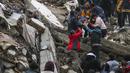 Orang-orang dan tim darurat menyelamatkan seseorang dengan tandu dari bangunan yang runtuh di Adana, Turki, Senin, 6 Februari 2023. Gempa berkekuatan magnitudo 7,8 telah menyebabkan kerusakan signifikan di tenggara Turki dan Suriah. (IHA agency via AP)