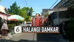 Petugas dan warga terpaksa bekerjasama mengangkat dan menggeser mobil tersebut untuk dimasukkan sementara ke garasi warga.
