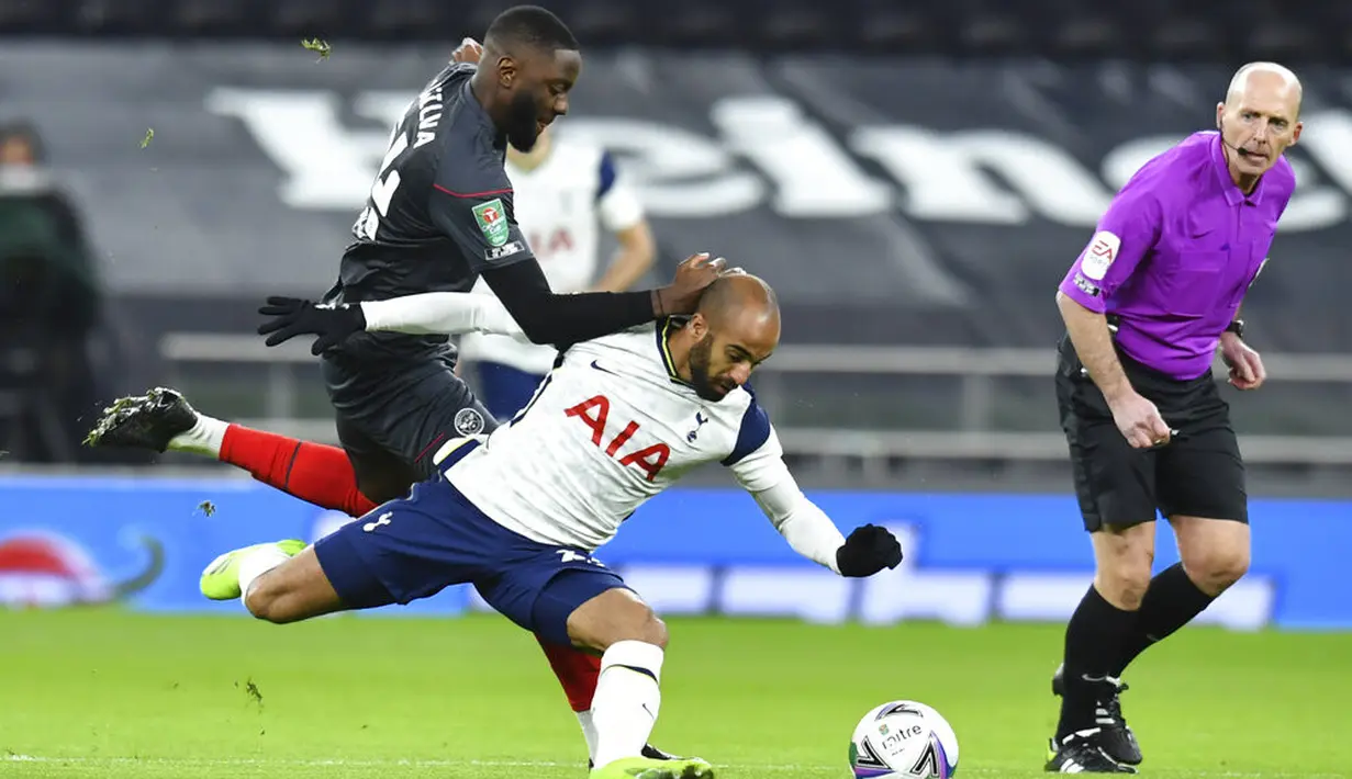 Pemain Tottenham Hotspur Lucas Moura (tengah) berebut bola dengan pemain Brentford Pelenda Joshua Dasilva pada pertandingan semifinal Piala Liga Inggris di Tottenham Hotspur Stadium, London, Inggris, Selasa (5/1/2021). Tottenham Hotspur menang 2-0. (Glyn Kirk/Pool via AP)