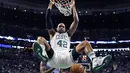 Aksi Pemain Boston Celtics, Al Horford (42) bergelantungan diatas ring usai melakukan dunk saat melawan Memphis Grizzlies, pada lanjutan NBA di TD Garden, (27/12/2016). (AP/Charles Krupa)