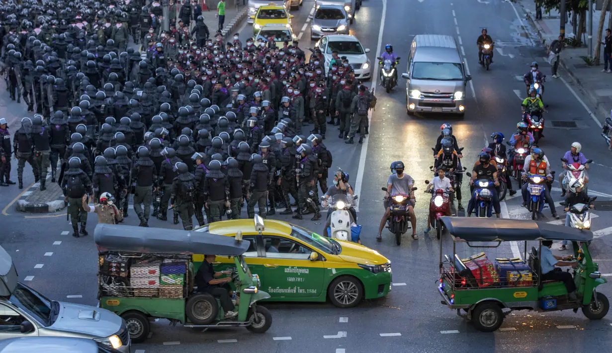 Polisi antihuru-hara mundur setelah mengejar sekelompok kecil demonstran pro-demokrasi dekat Gedung Pemerintah di Bangkok, Thailand, Kamis (15/10/2020). Polisi Thailand membubarkan demonstran yang berunjuk rasa di luar kantor perdana menteri. (AP Photo/Gemunu Amarasinghe)