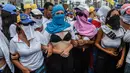 Sejumlah wanita membuka kausnya saat berunjuk rasa menentang Presiden Venezuela Nicolas Maduro di Caracas, Sabtu (6/5). Mereka meneriakkan “Liberty” dan wanita-wanita tersebut menyebut Maduro sebagai seorang diktator. (AFP PHOTO / JUAN BARRETO)