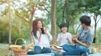 Sebuah keluarga kecil yang terdiri dari ayah, ibu, dan seorang anak laki-laki sedang mengadakan piknik di taman (Foto Dok: Freepik/mkitina4).