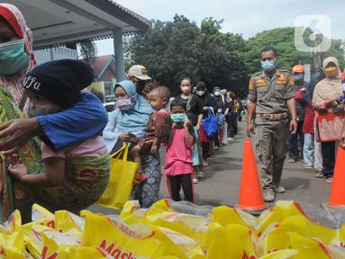 Seorang ibu membawa anaknya membeli minyak goreng kemasan saat operasi pasar minyak goreng murah di Kantor Kecamatan Pamulang, Tangerang Selatan, Selasa (11/1/20222). Minyak murah itu dijual dengan harga Rp14 ribu per liter dan hanya diperbolehkan membeli sebanyak 2 liter. (merdeka.com/Arie Basuki)