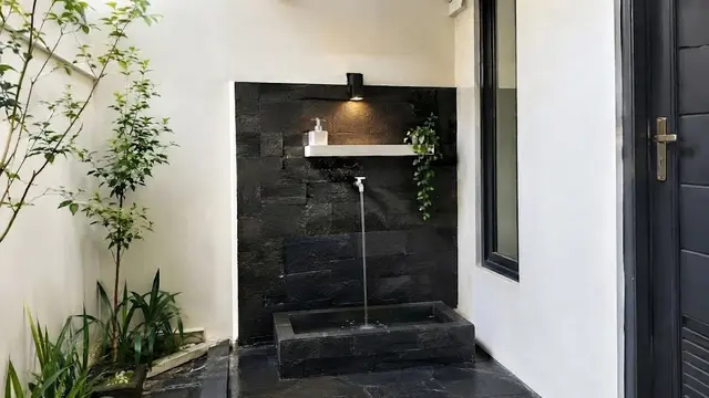 Desain Tempat Wudhu di Samping Rumah dengan Lantai Batu Bertekstur