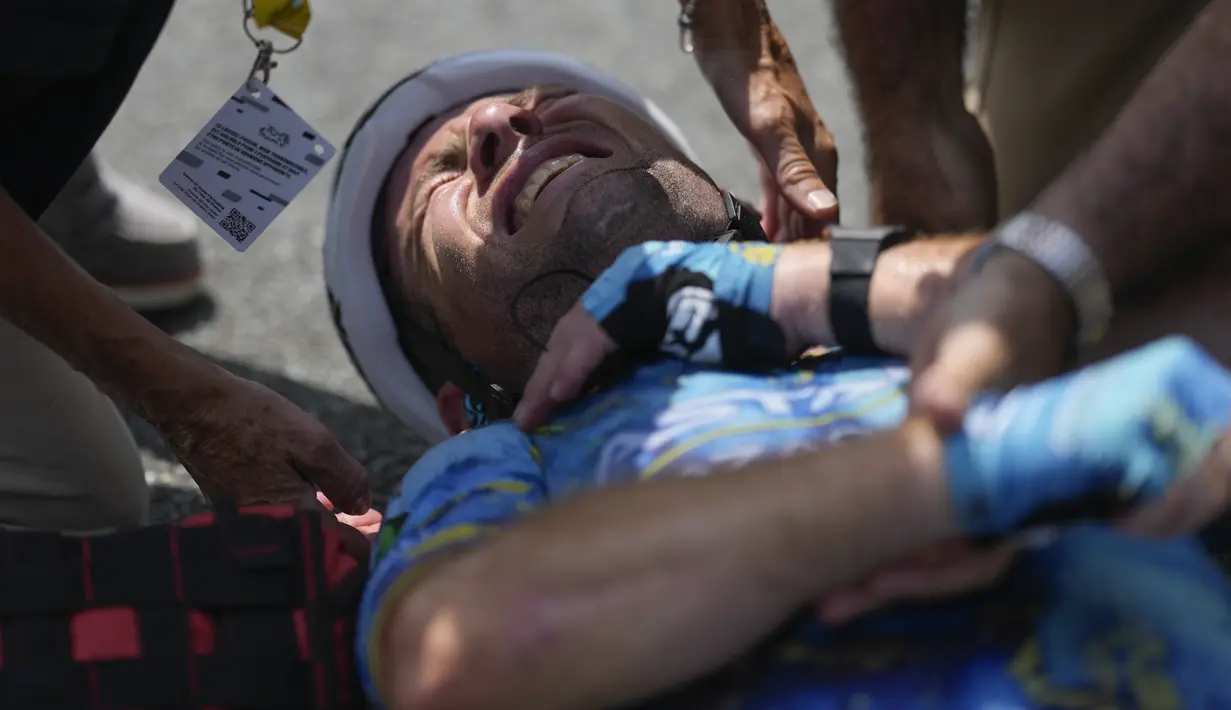 Cavendish yang berwajah pucat tetap berada di jalan sambil berguling-guling kesakitan setiap kali ia memegang bahu kanannya sebelum dievakuasi ke rumah sakit dengan ambulans. (AP Photo/Thibault Camus)