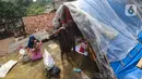 Warga beraktivitas pada tenda darurat yang dibangun di atas rumah pasca banjir melanda kawasan Pejaten Timur, Jakarta Selatan, Senin (8/1/2024). (merdeka.com/Arie Basuki)