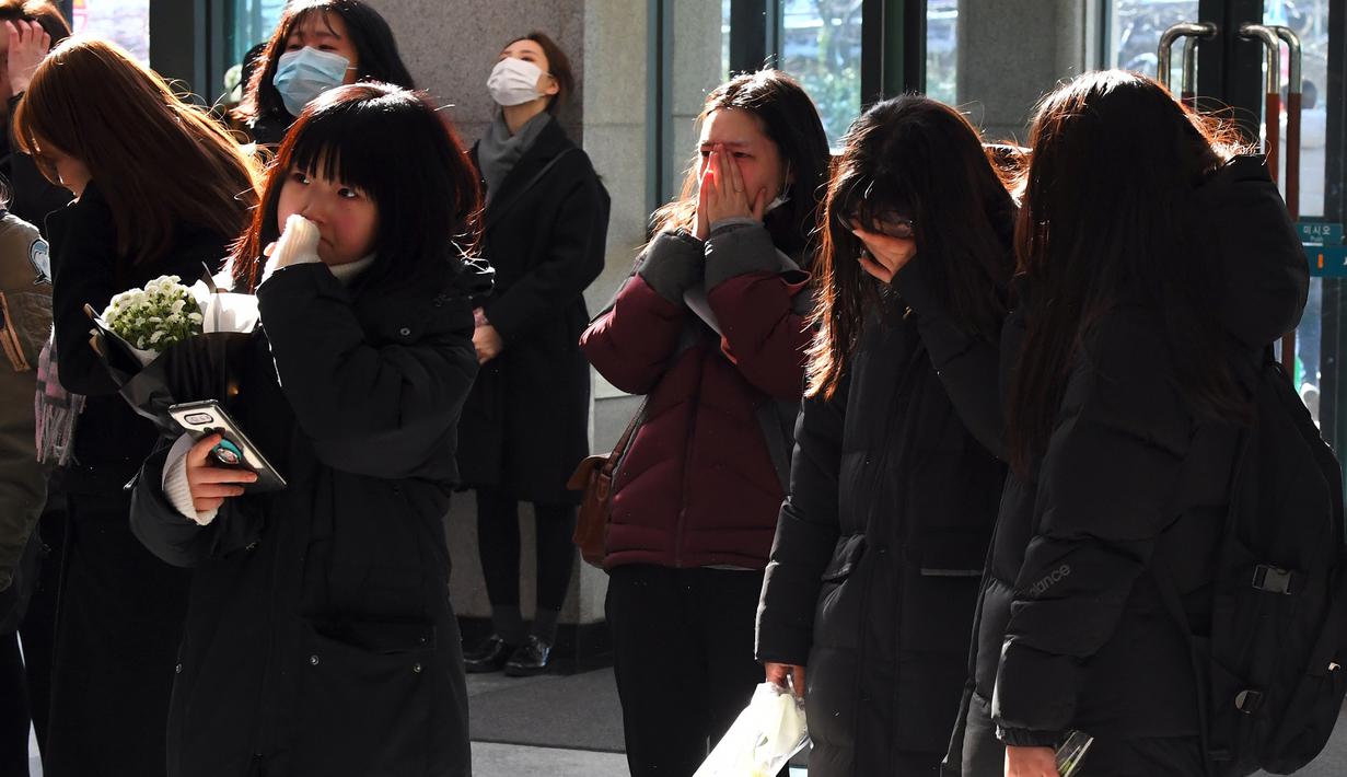 Para fans menangis saat datang memberikan penghormatan kepada Jonghyun SHINee di rumah duka Seoul Asan Hospital, Selasa (19/12). SM Entertainment dan keluarga Jonghyun memutuskan untuk memberi kesempatan bagi para fans untuk melayat. (JUNG Yeon-Je / AFP)