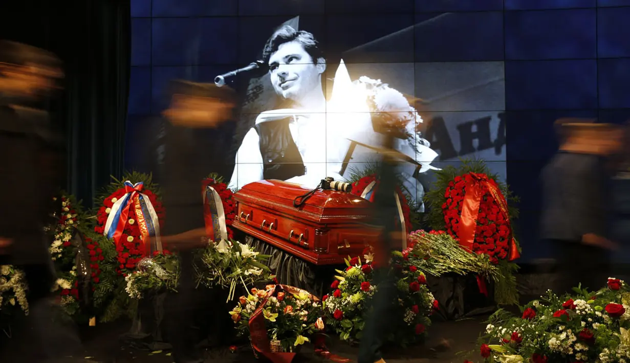 Beberapa orang melintas usai memberikan penghormatan kepada jenazah Andrei Stenin, wartawan foto Rusia yang hilang sejak awal Agustus dan ditemukan tewas di Ukraina, (5/9/2014). (AFP PHOTO/Alexander Nemenov)
