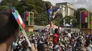 Seorang wanita memegang bendera Prancis saat dia melakukan akrobat di zona penggemar Olimpiade di Trocadero di Paris, Minggu (8/8/2021). Warga Paris pun antusias menyambut pagelaran pesta olahraga terbesar di dunia itu. (AP Photo/Francois Mori)