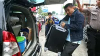 Penyidik KPK memasukkan koper berisi dokumen ke dalam mobil usai menggeledah kantor mantan kuasa hukum Setya Novanto, Fredrich Yunadi, di Jakarta, Kamis (11/1). Sebanyak empat mobil membawa para penyidik dan barang bukti. (Liputan6.com/Johan Tallo)