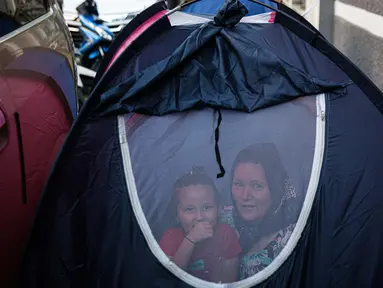 Pengungsi Afghanistan terlihat berada di dalam tenda di trotoar Kawasan Kebon Sirih, Jakarta, Kamis (26/8/2021). Sebanyak 20 pengungsi asal Afghanistan kembali menempati trotoar dengan harapan bisa diterbangkan ke negara lain dan mendapatkan kehidupan yang lebih layak. (Liputan6.com/Faizal Fanani)