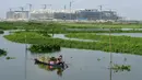 <p>Seorang petani memanen mimosa air dari perahu di sebuah perkebunan di Phnom Penh, Kamboja, 28 April 2022. Mimosa air adalah hidangan sayuran yang populer di Kamboja. (TANG CHHIN Sothy/AFP)</p>