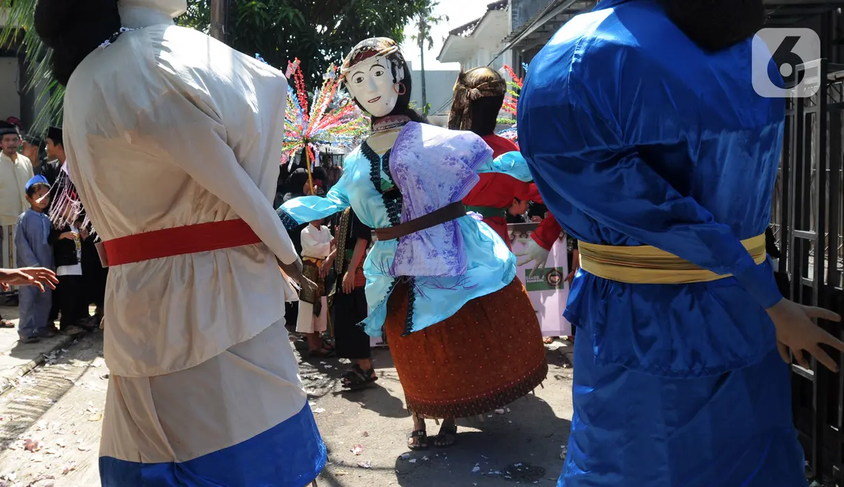Ondel-ondel tampil pada pawai jelang Ramadan di kawasan Pondok Cabe Ilir, Tangerang Selatan, Banten, Minggu (27/3/2022). Kegiatan yang diselenggarakan Sanggar Seni Rumah Baba ini diikuti puluhan warga. (merdeka.com/Arie Basuki)