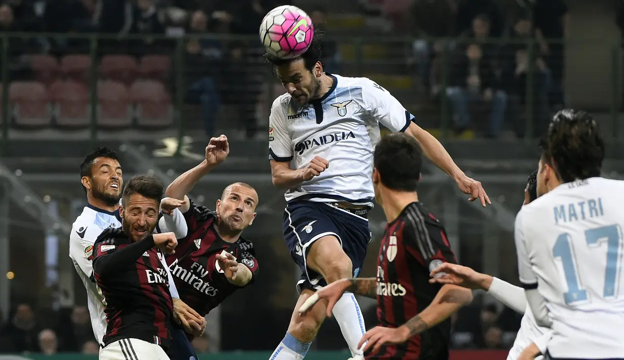Gelandang Lazio, Marco Parolo (tengah) saat menyundul bola dari kawalan pemain AC Milan pada Liga Serie A Italia di Stadion San Siro (21/3). AC Milan bermain imbang dengan Lazio dengan skor 1-1. (AFP/Olivier Morin)