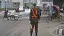 Tentara Bangladesh menjaga pos pemeriksaan sepanjang jalan di Dhaka, Bangladesh, Kamis (1/7/2021). Mulai 1 Juli diberlakukan lockdown, Tentara dan Polisi Bangladesh diperintahkan untuk menghentikan orang-orang yang meninggalkan rumah mereka kecuali untuk keadaan darurat. (AFP/Munir Uz zaman)