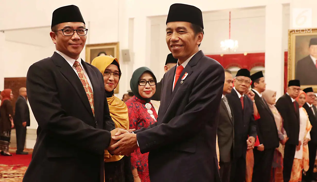 Presiden Jokowi memberikan ucapan selamat kepada Hasyim Asy'ari yang berasal dari unsur KPU seusai pelantikan anggota Dewan Kehormatan Penyelenggara Pemilu (DKPP) periode 2017-2022 di Istana Negara, Jakarta, Senin (12/6). (Liputan6.com/Angga Yuniar)